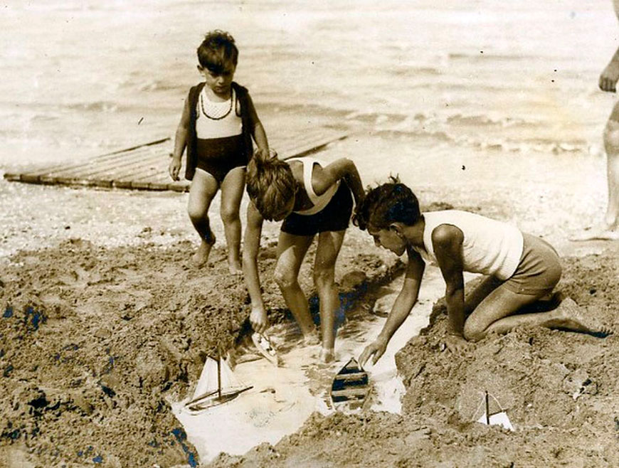 Children at the beach with a toy sailboat (Дети на пляже с игрушечным парусником), 1934