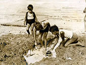 Children at the beach with a toy sailboat / Дети на пляже с игрушечным парусником