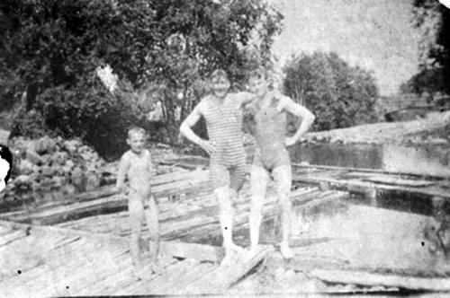 Gruppe 2 menn i stripete badedrakter og en naken liten gutt, på badstranden (Двое мужчин в полосатых купальных костюмах и голый маленький мальчик на пляже), 1917