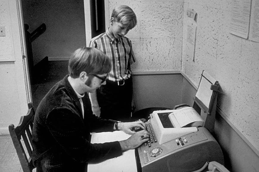 Gates (13) watches his friend and future Microsoft co-founder Paul Allen typing on a teletype terminal (Гейтс (13) наблюдает, как его друг и будущий соучредитель Microsoft Пол Аллен печатает на телетайпе), 1968