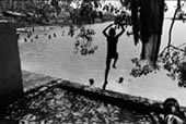 Мальчик. прыгающий в озеро с уступа