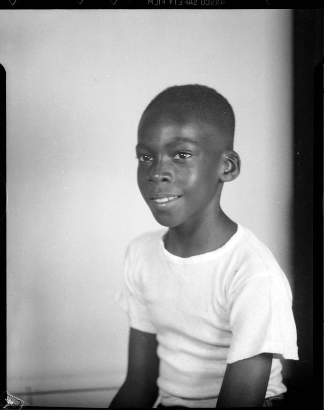 Portrait of a smiling boy wearing light colored T-shirt, possibly in studio (Портрет улыбающегося мальчика в светлой футболке, возможно, в студии), 1935-1950