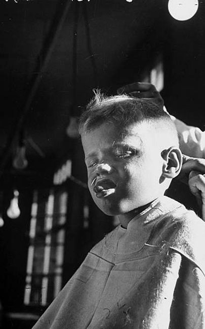 Four year old boy closing eyes and grimacing while receiving haircut (Четырехлетний мальчик, закрывающий глаза и строящий гримасы при стрижке), 1947
