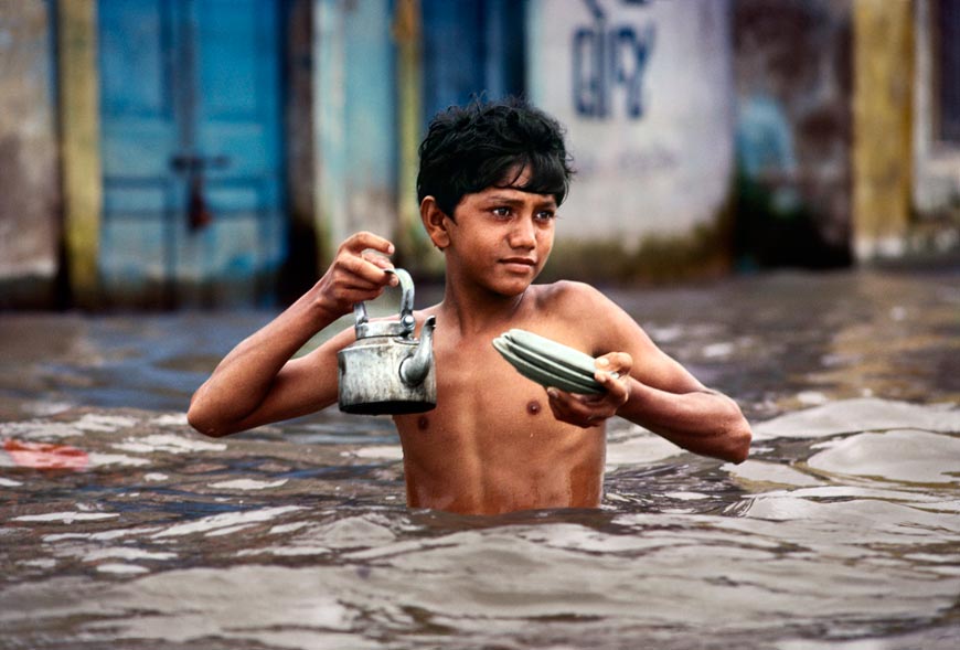 Tea vendor carries tea kettle in waist deep monsoon water (Продавец чая по пояс в муссонной вод несет чайник), 1983