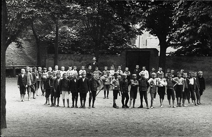 Bubenklasse auf dem Schulhof mit Lehrer (Класс мальчиков с учителем на школьной площадке), 1920s
