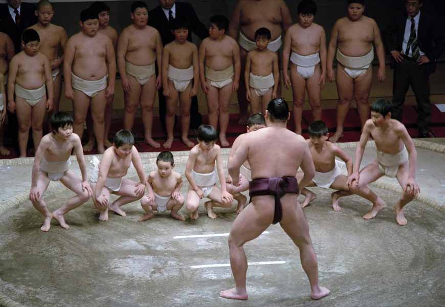 Inside the Kokugikan at a charity event sumo wrestlers are challenged by children from a sumo club, 2004