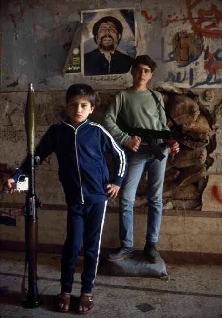 Young Shi`ite militia pose in front of a poster of their spiritual leader Imam Musa al-SADR, kidnapped by the Lybians, 1985